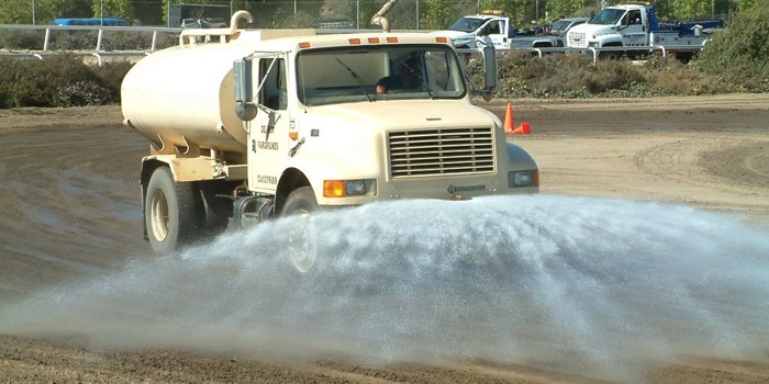 A truck spraying water on the ground