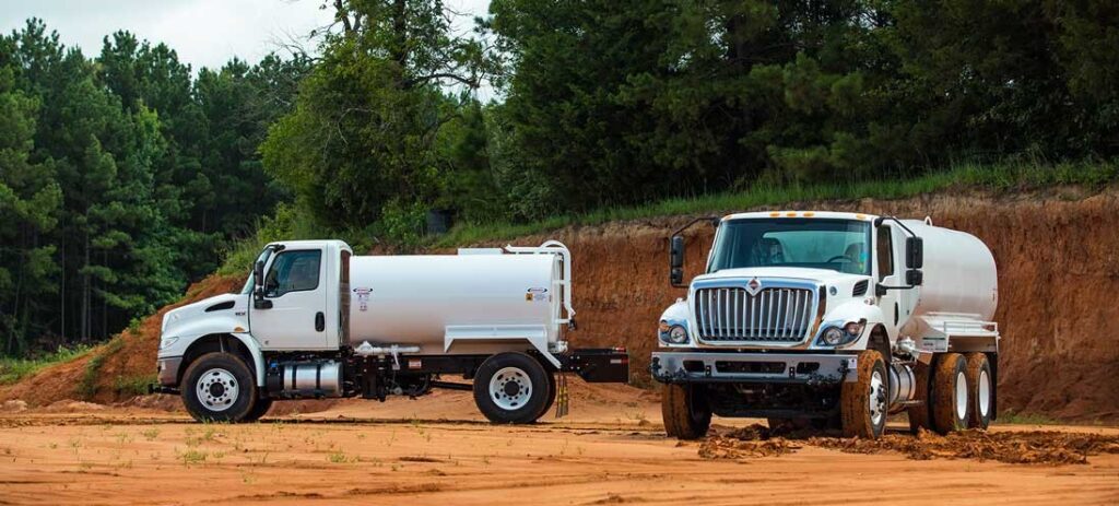 Two parked trucks on a muddy area